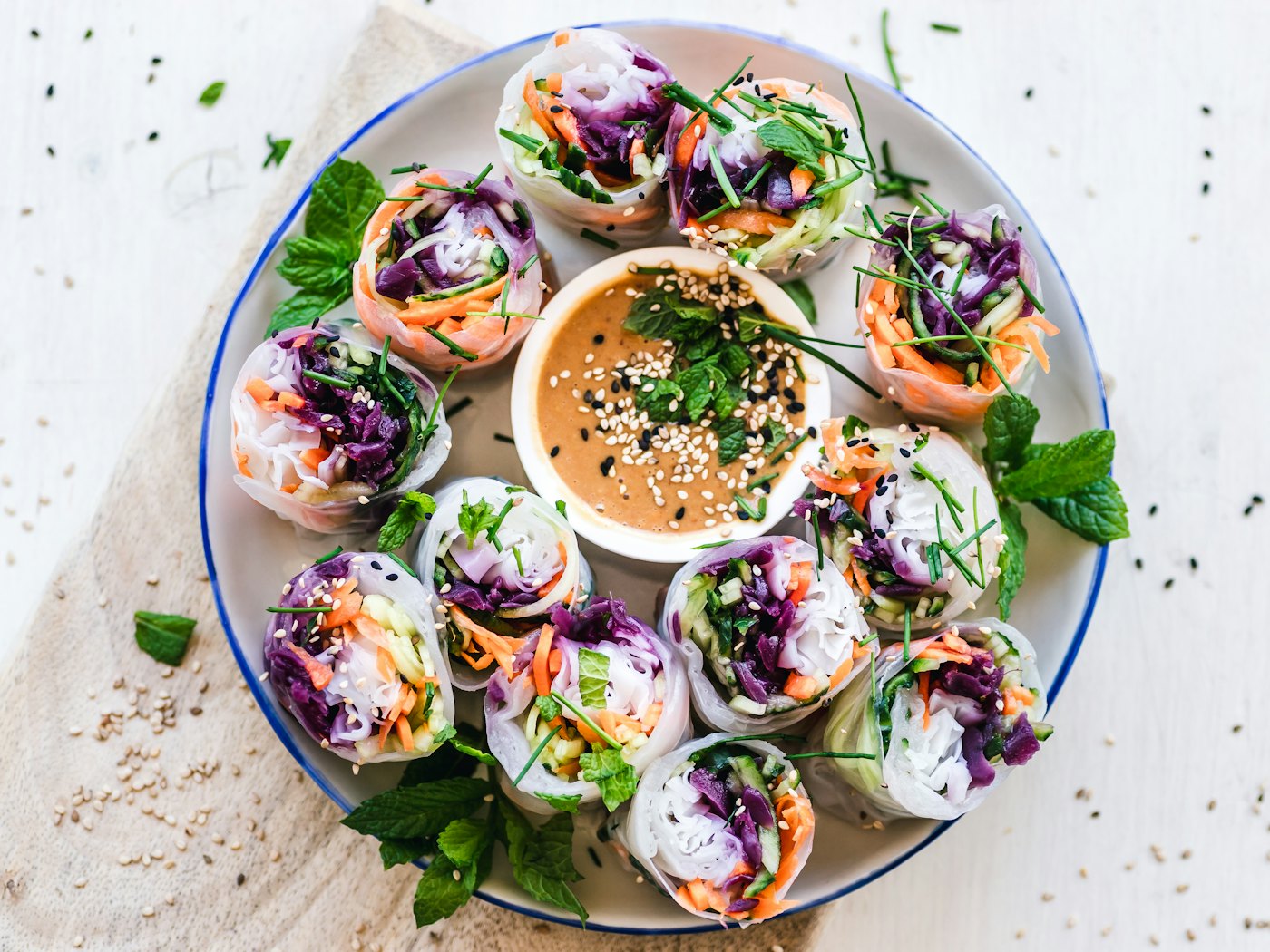 Rouleaux de printemps frais et sauce cacahuète sur une assiette à liseré bleu